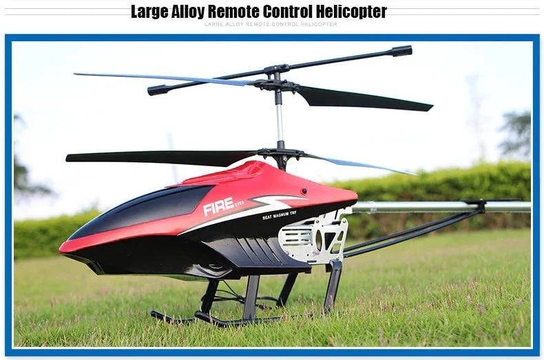 Large alloy RC helicopter with remote control on grass.