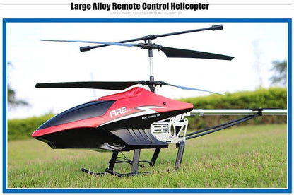 Large alloy RC helicopter with remote control on grass.